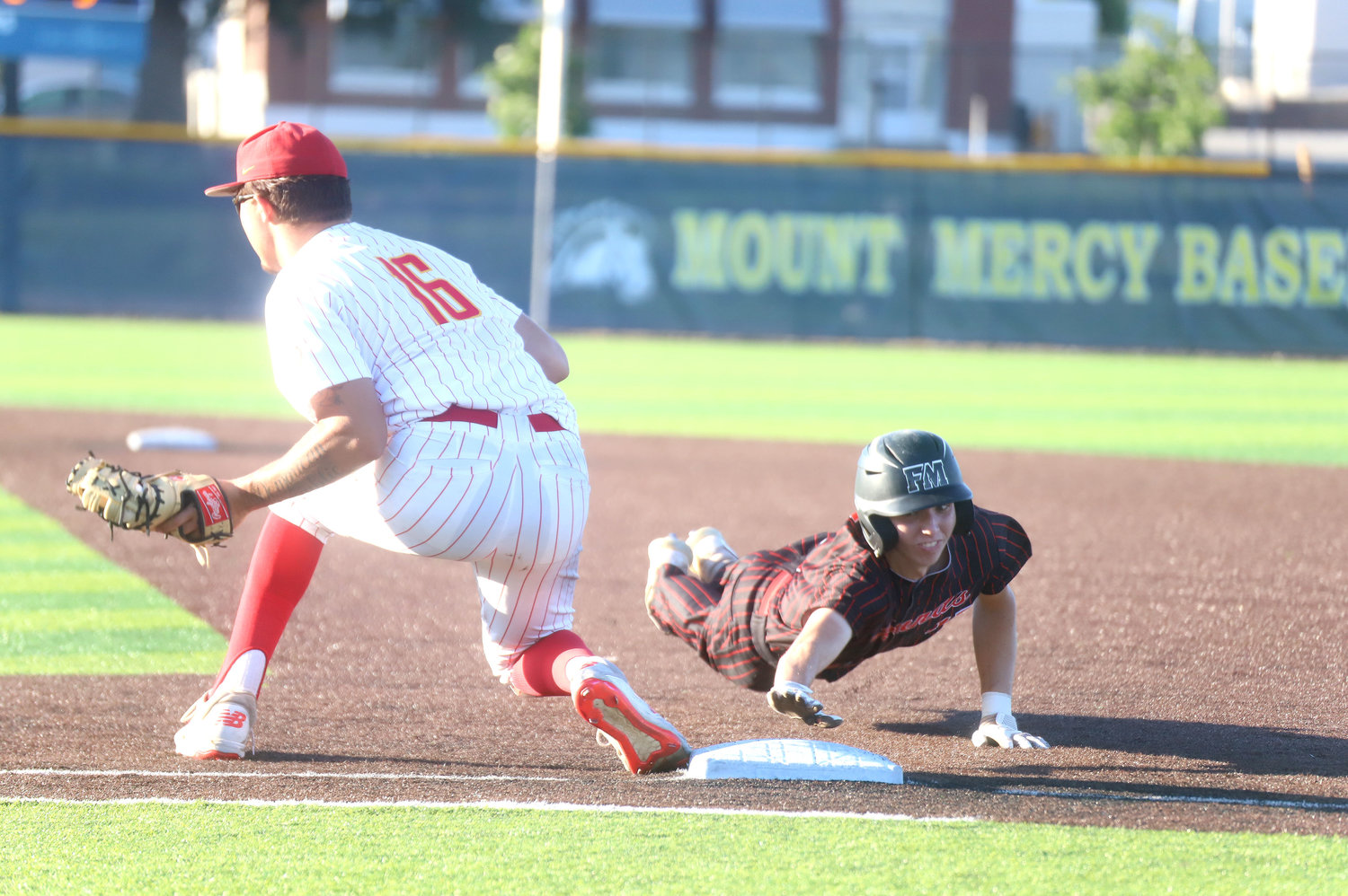 Fort Madison's Matt Hopper dives back into first base in the first inning of the Bloodhounds' 12-2 loss to Marion at the Substate 5 semifinal at Mt. Mercy University in Cedar Rapids Monday night