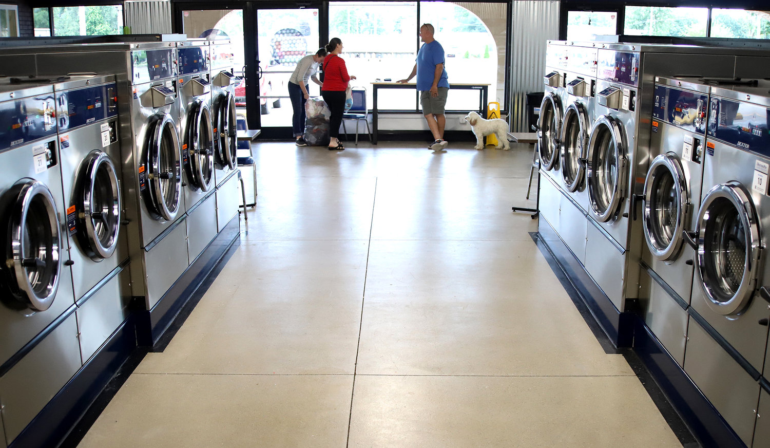 Ave. O Laundry owner Jim Cobb talks with some customers Tuesday about upcoming services at the new facility in The Plaza at Fort Madison.