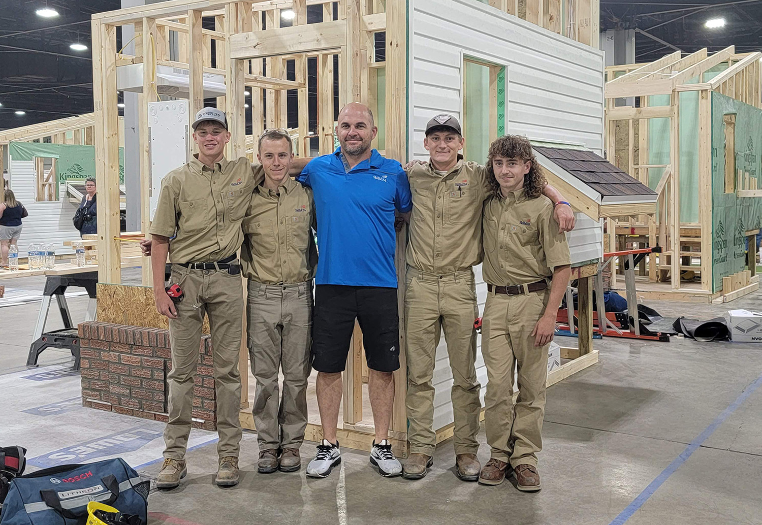 From left to right Emmett Kruse, Hayden Wolfe, Instructor Clint Kobelt, Landes Williams, and Andrew Schaefer stand in front of their national Skills USA TeamWorks project in Atlanta Thursday evening. The team received a silver medal in the TeamWorks competition, making them the second-best high school team in the country. Courtesy photo