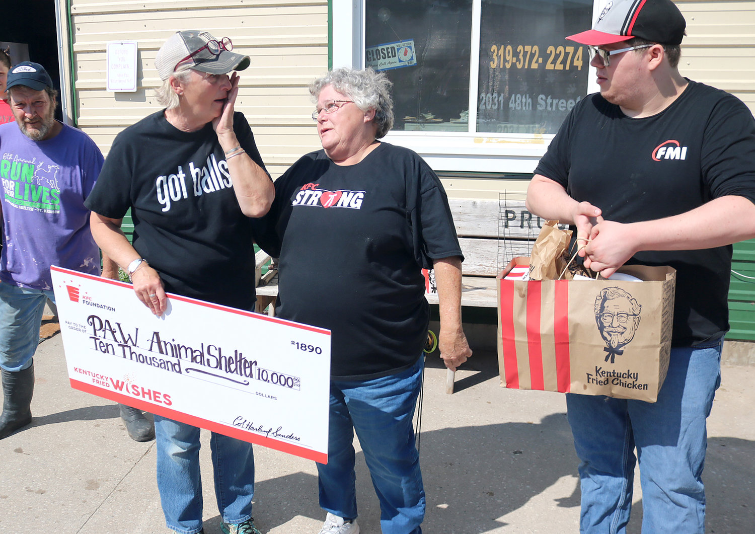 PAW Animal Shelter director Sandy Brown wipes away tears after receiving a $10,000 check Saturday morning from KFC manager Kathy Neff, center and Andrew Sheaffer of Burilngton KFC.