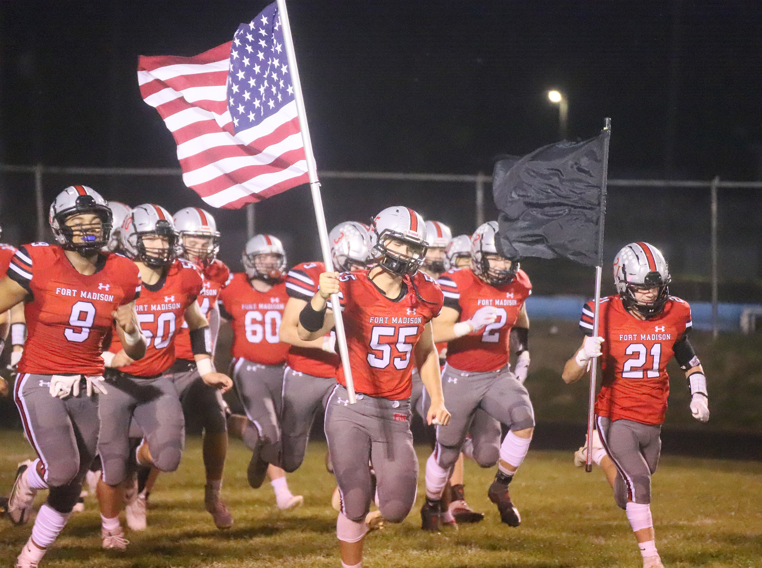The Fort Madison Bloodhounds bring the American Flag into the stadium as part of the normal routine to start all football games.