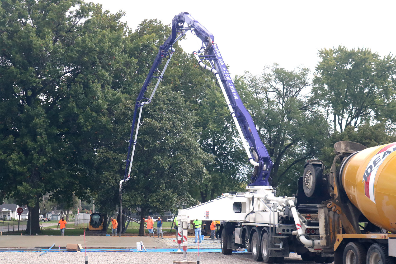 Construction crews pour cement between the sprinkles on Wednesday morning at Victory Park in Fort Madison. The new surface will be the home for six new pickleball courts.