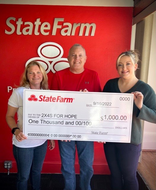 Fort Madison State Farm agent Jess Sutcliffe presents a check for $1,000 to 2x4s for Hope as part of the Good Neighbor program.