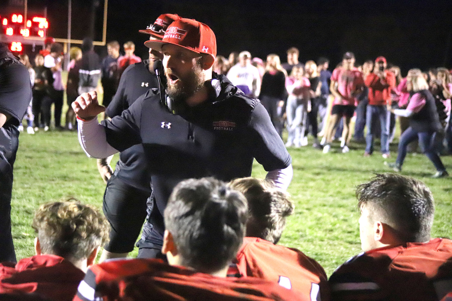 Head Coach Derek Doherty congratulates the Hounds after their come-from-behind victory over Burlington Friday in Fort Madison.