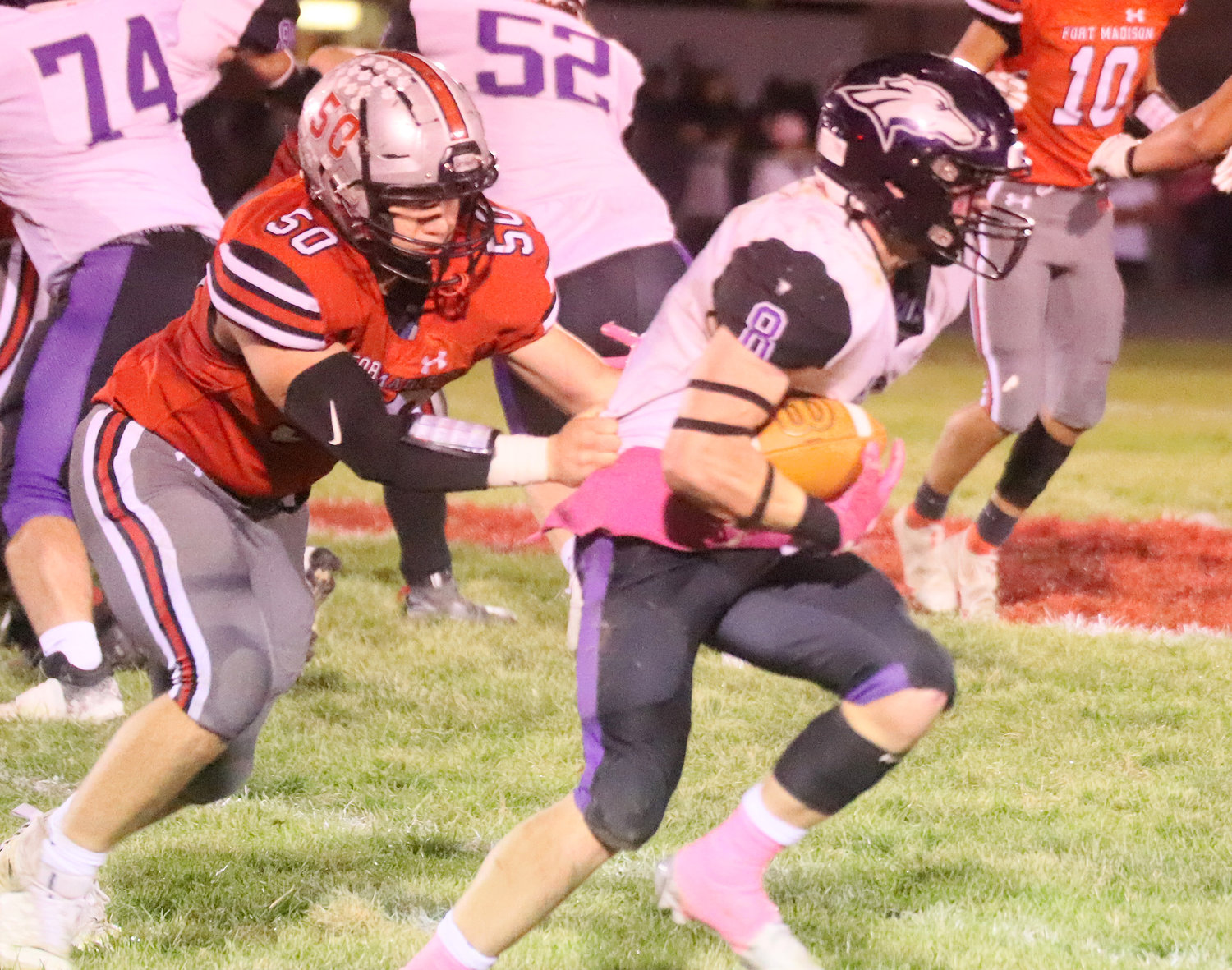 Ike Thacher pulls down Caden Schisel in the backfield for a loss of yardage Friday night in Fort Madison.