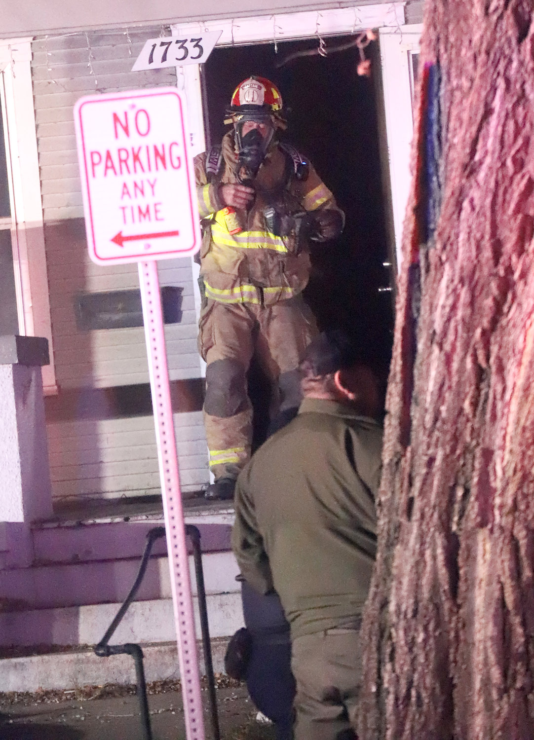 Firefighter Jay Blanchard exits the front door of a home at 1733 Avenue L Wednesday night. Fire broke out on the first floor of the home at about 9:15 sending one to an Iowa City hospital.