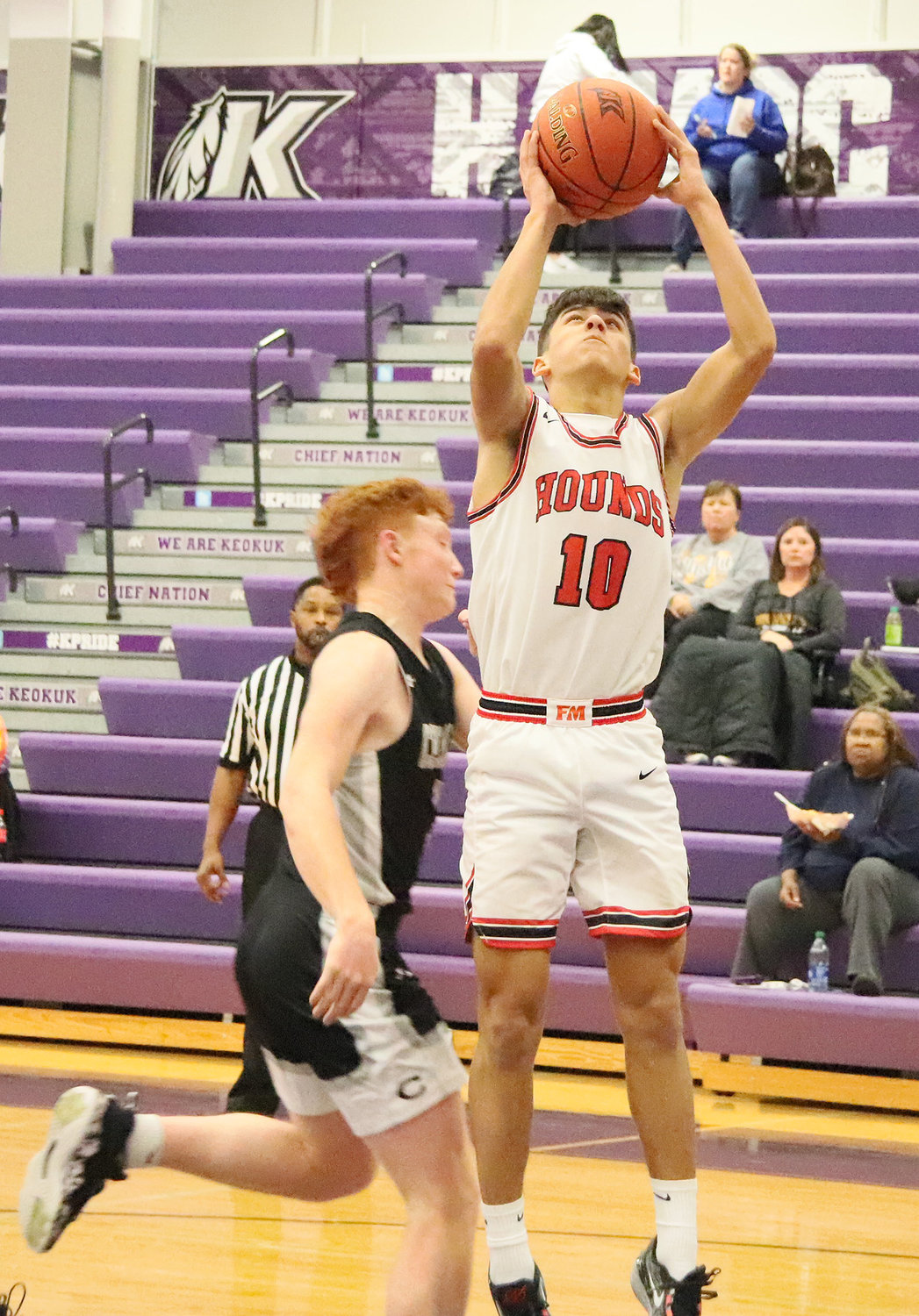 Leif Boeding (10) pulls up for a short jumper Saturday at Keokuk High School. Boeding finished with 16 points for the Bloodhounds.