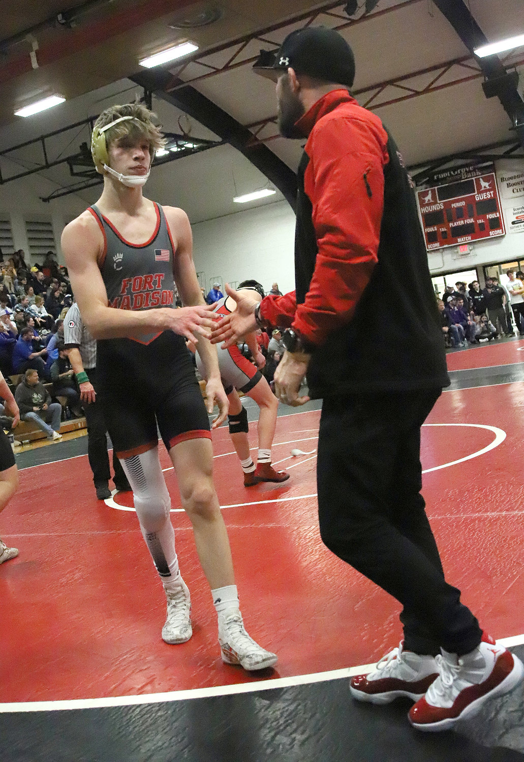 Fort Madison's Nolan Riddle gets congratulated from assistant coach Derek Doherty after taking 3rd at 145 pounds at Saturday's Fort Madison Invitational.
