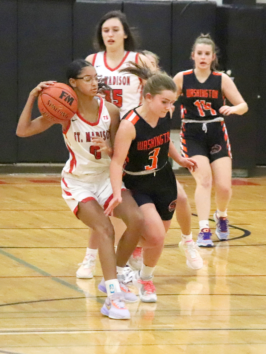 Fort Madison’s Aija Jenkins (0) wrestles the  ball away from Washington’s Makenna Conrad in the 4th quarter Tuesday night in Fort Madison. The Hounds won 52-46.