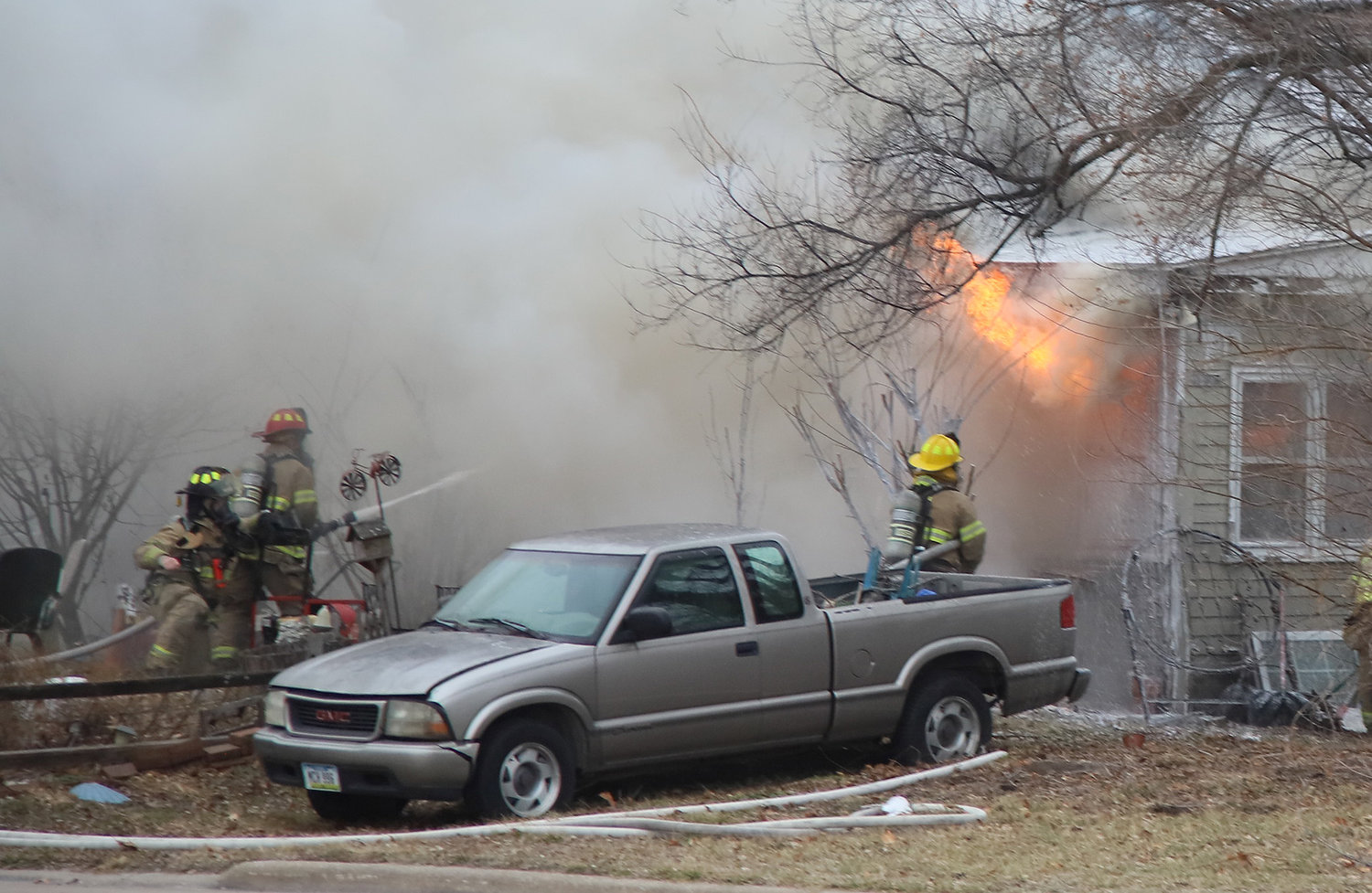 Fire leaps from the front porch of a home in the 1600 block of 33rd Street Thursday afternoon. Firefighters battled the fire for about two hours.