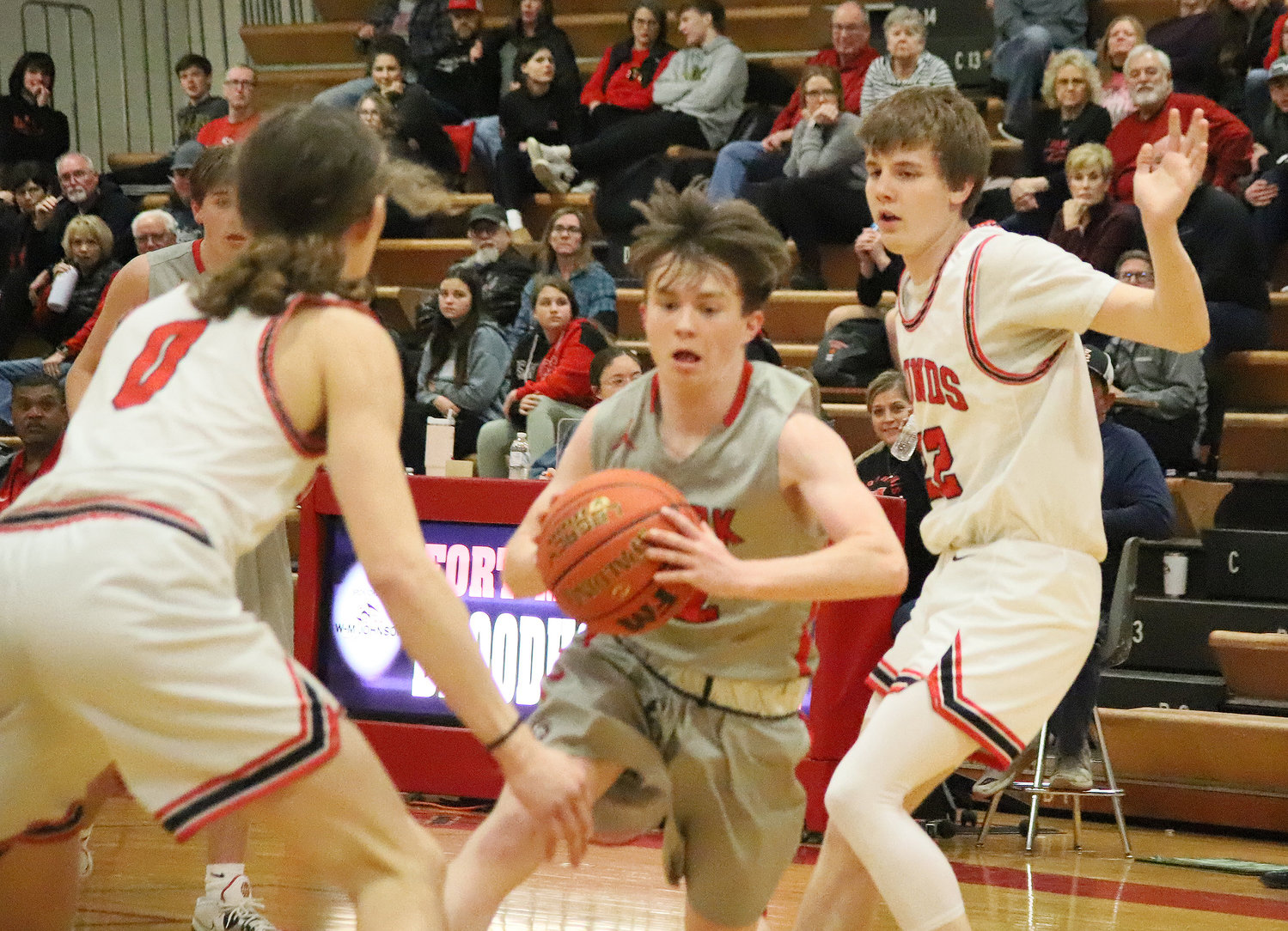 Clark County's Garrett Billings looks for a passing lane between Fort Madison's Cade Packard (0) and William Bennett (22) in the fourth quarter of the Hounds' 69-34 win Tuesday night.