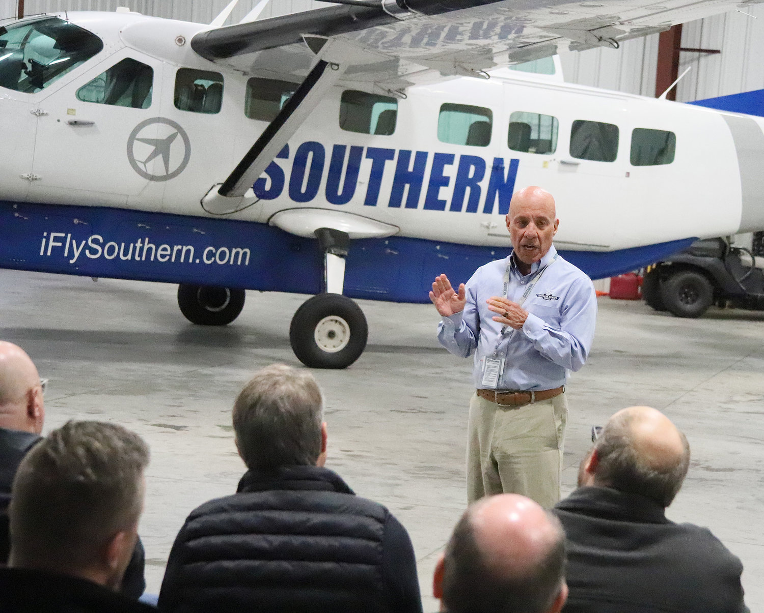 Southern Airways Chief Commercial Officer Mark Cestari speaks with dignitaries in the large hangar at the Burlington Airport Tuesday morning.