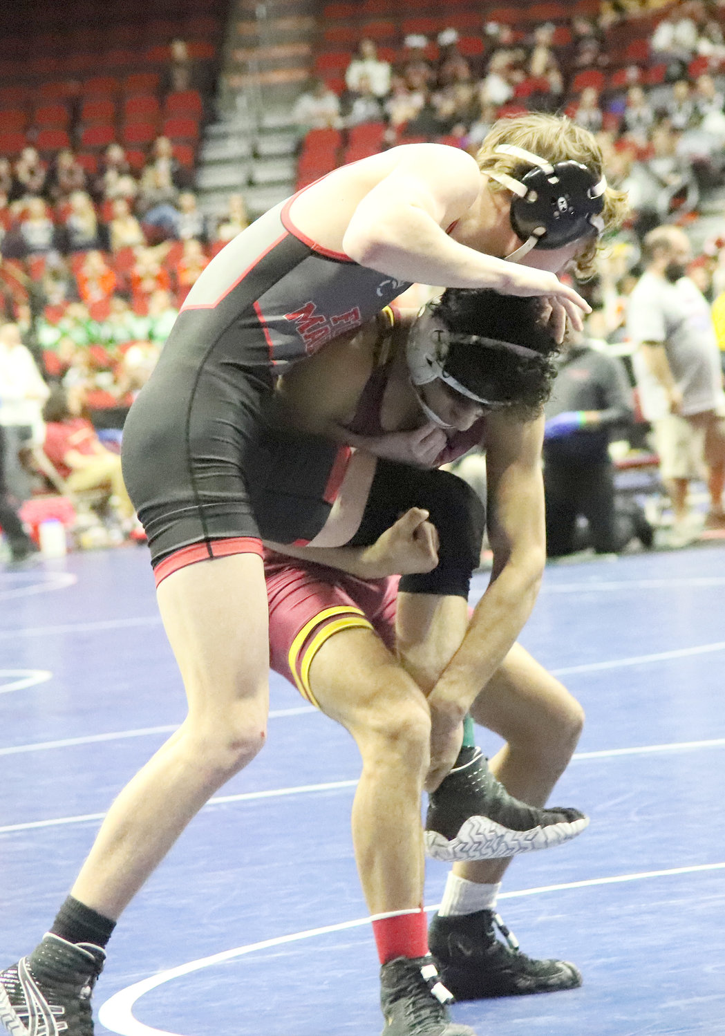FMHS sophomore Noah Swigart tries to get out of a leg grab by Ankeny's JJ Maihan in the first period of early action Thursday night at Wells Fargo Arena in Des Moines.