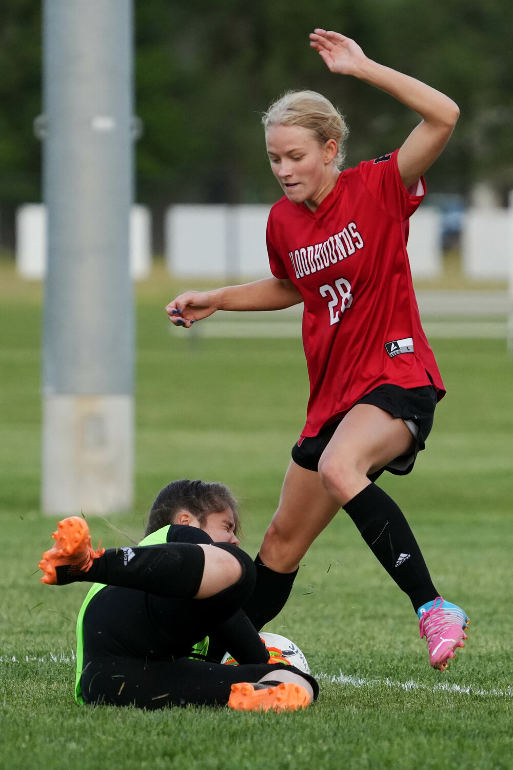 The Lady Hounds' Teagan Snaadt (28) collides with goalkeeper Kyla Muston during quarterinal action Friday, May 19,at Baxter Sports Complex.