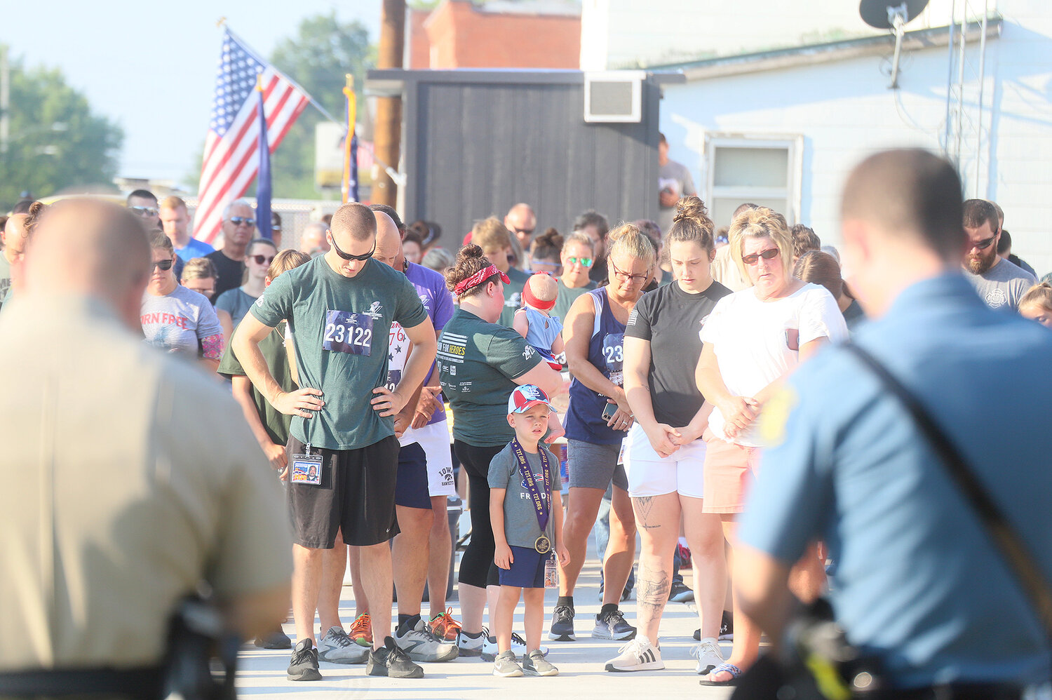 Runners bow for a prayer before the start of the Tunnel to Towers 5K run in Donnellson Tuesday morning.