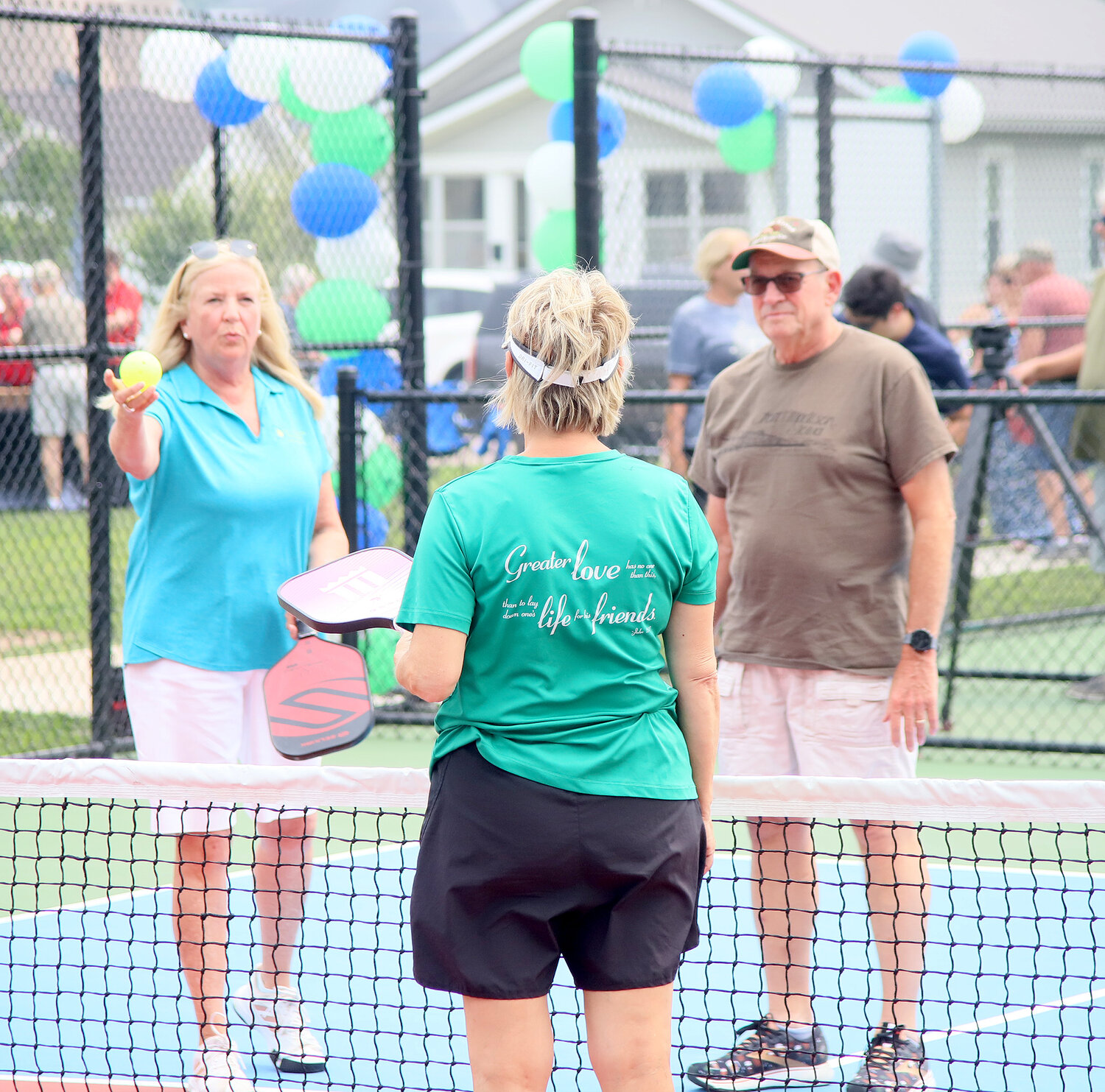 Fort Madison Pickleball Association's Lynn Hoyer gives a brief tutorial to Fort Madison Mayor Matt Mohrfeld, right, and his wife Beth Mohrfeld, center, at Sunday's grand opening of the Fort Madison Pickleball courts in Victory Park in Fort Madison.