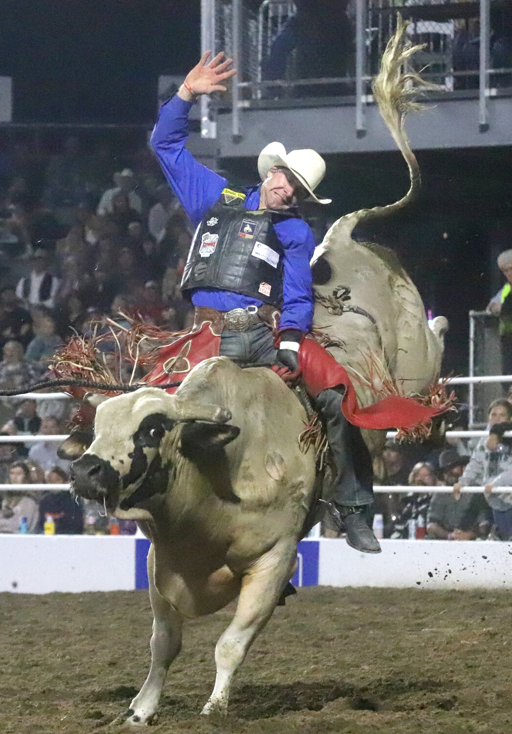 Leroy Miller of Moravia, Iow,a hangs on for a ride in the saddlebronc event Wednesday night as the 75th Anniversary of the Tri-State Rodeo kicked off with the Jim Baier/Dodge Ram Chute-Out.