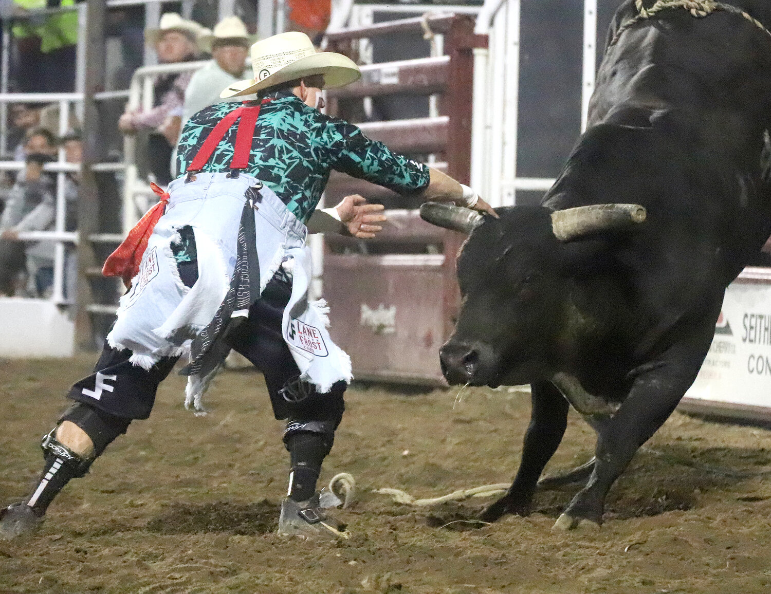Rodeo Bullfighter Nathan Harp steps in to tangle with a ramped up bull during the bullfighting session of Wednesday's Jim Baier/Dodge Ram Chute-Out at the Tri-State Rodeo in Fort Madison.