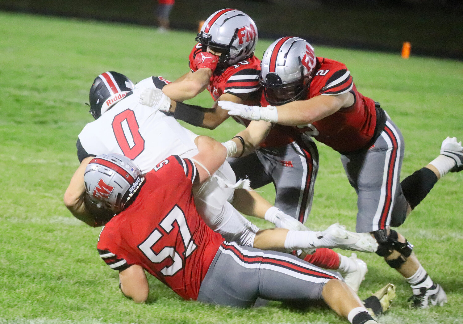 Fort Madison's Tristan Marshall and Teague Smith bring down Williamsburg's Braylon Wetjen in the first quarter of the Hounds' 48-14 loss to the Raiders in Fort Madison.