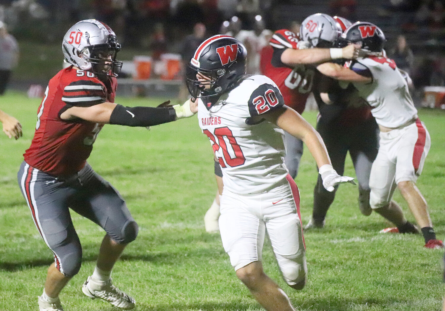Senior Ike Thacher engages with the Raiders' Dylan Weisskopf on the front end of a running play in the fourth quarter Friday night in Fort Madison.