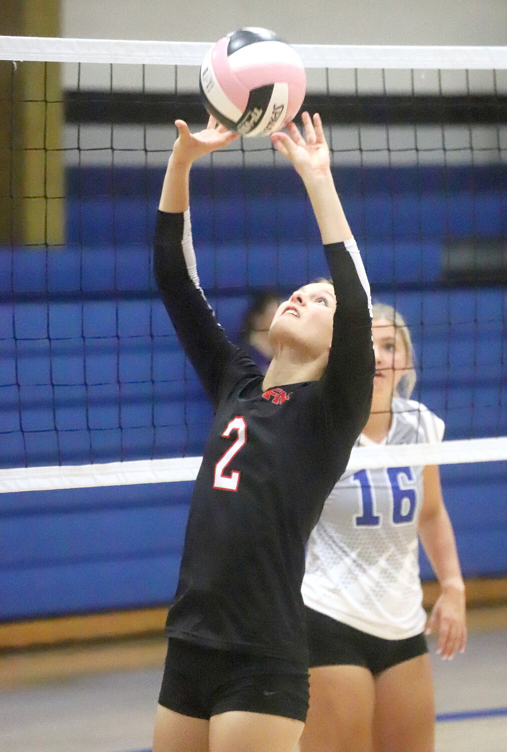Fort Madison's Mara Smith puts up an assist in the second set of the Bloodhounds' match with HTC Monday night.