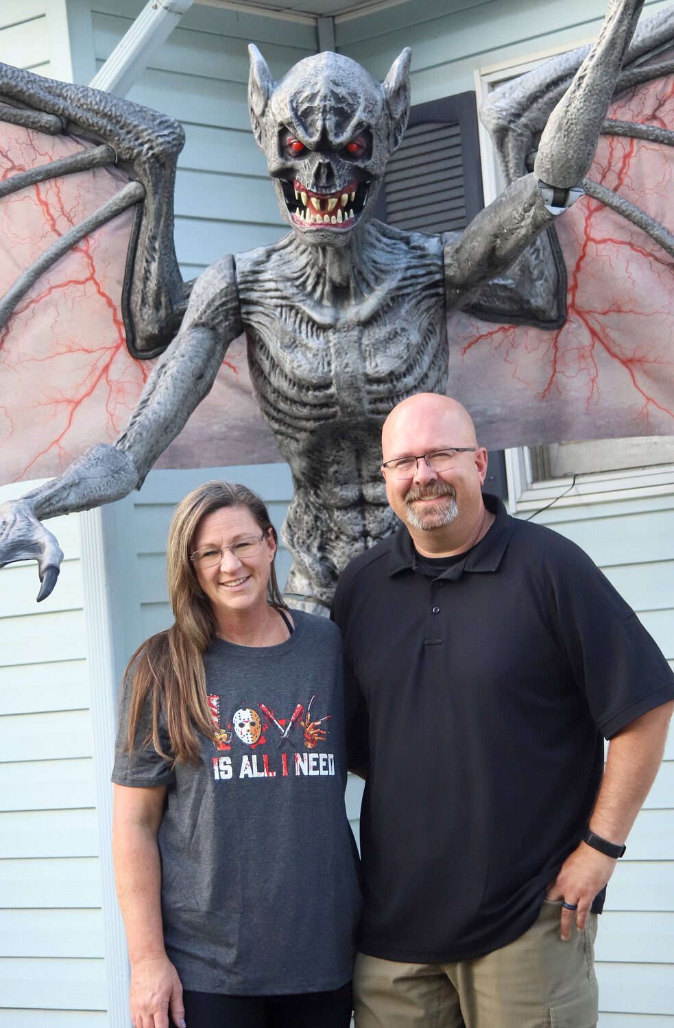 Chad and Denise Donaldson stand underneath an 8-foot gargoyle outside their home in Fort Madison. The Donaldsons set up a large Halloween display on their property at the corner of 18th and Avenue D.