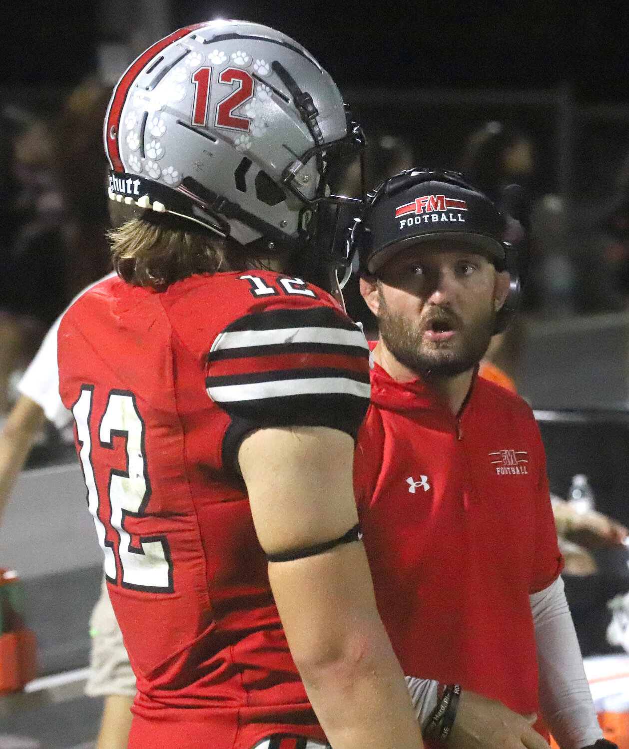 Fort Madison Head Coach Derek Doherty takes a moment with quarterback Marcus Guzman on the sideline Friday night in the Hounds' win over the Chiefs.