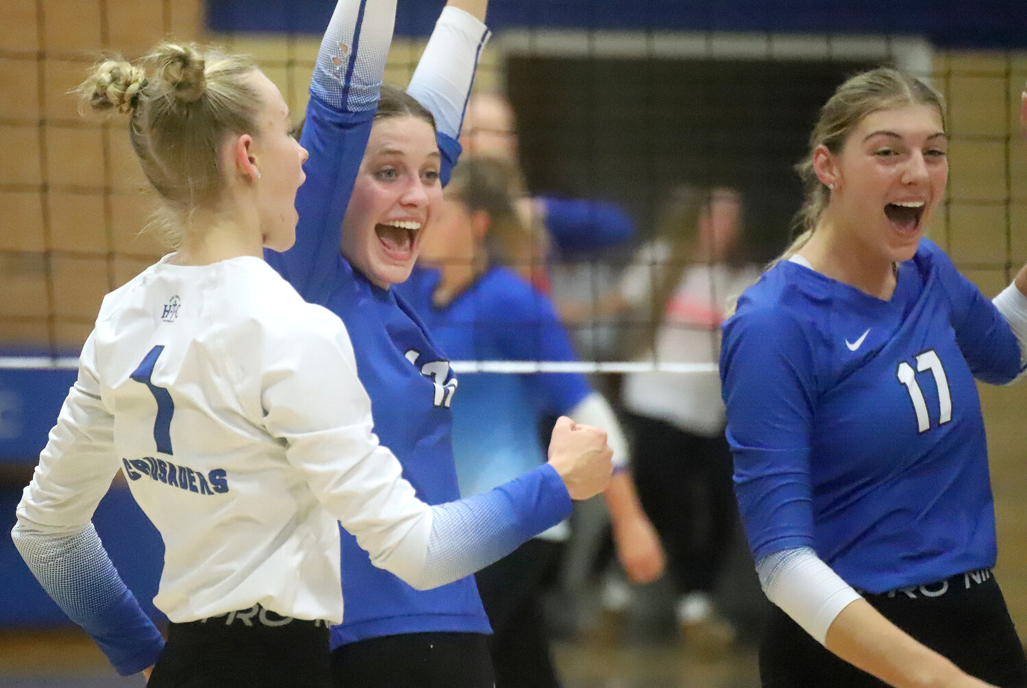 HTC's Teagan Snaadt, Mary Kate Bendlage, and Presley Myers celebrate a point in the second set as the Crusaders opened up an 18-1 lead over Danville en route to a sweep in the Region 8 quarterfinals Wednesday at Shottenkirk Gym.