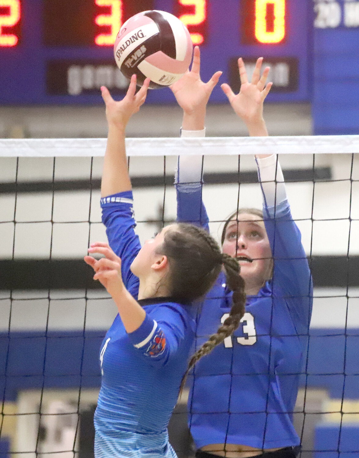 Senior Mary Kate Bendlage (13) battles for a ball above the net with a Danville Bear Wednesday in Fort Madison. Holy Trinity won in three sets to advance to the Class 1A Region 8 semifinals Monday night.