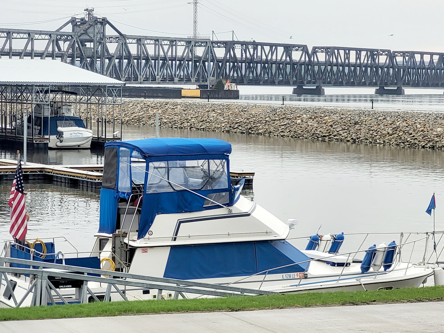A boat pulls in to the new marina for fuel on its trek up the river Thursday in Fort Madison, with the new jetty wall trail and the BNSF double decker swing span bridge in the backdrop.