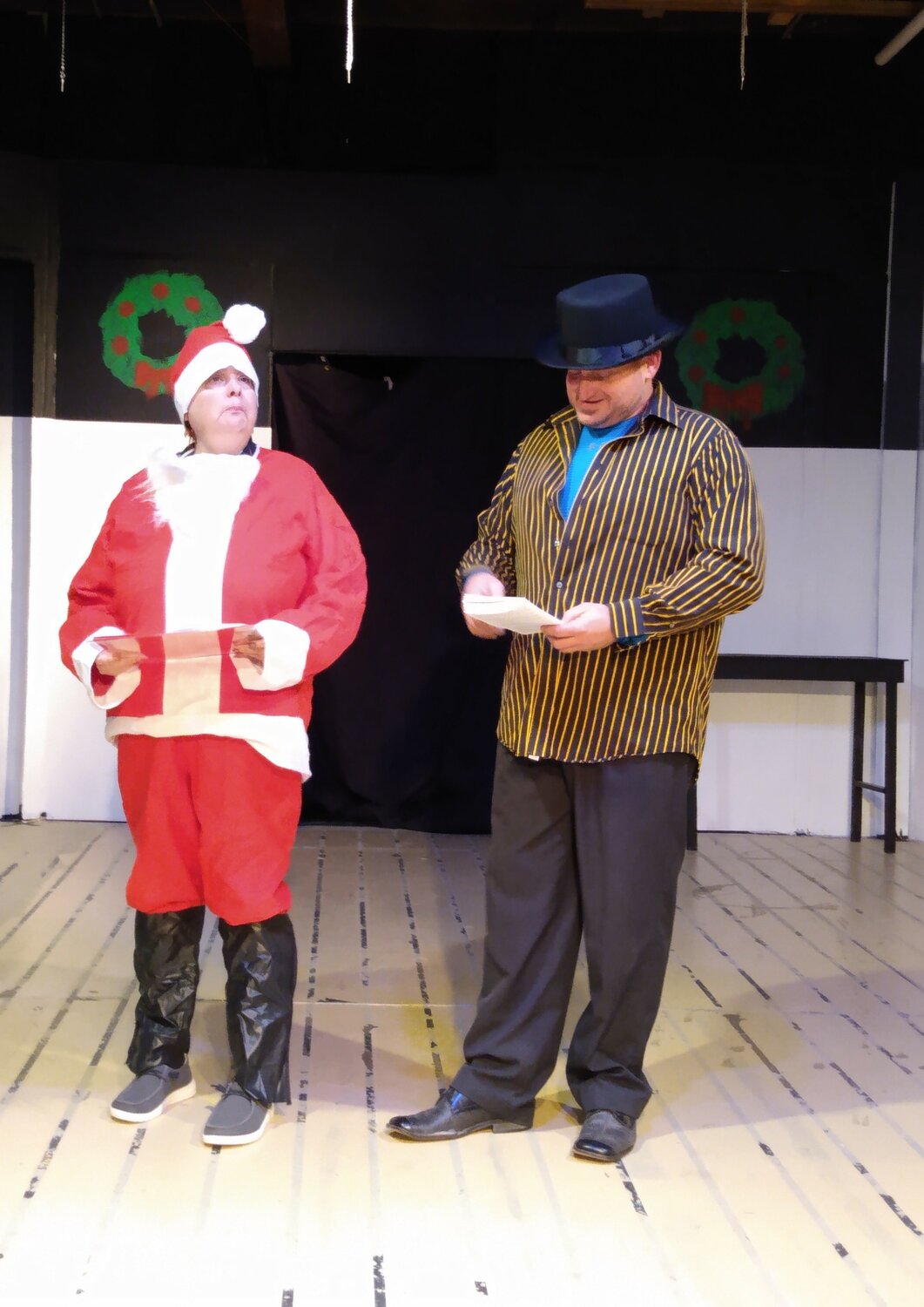 Ty Clute plays grumpy scrooge, while Kim Albers dressed as Santa plays Brynn a cast member who took an antihistamine that has made her loopy an she can't remember what play she is in and comes out as all the wrong characters.