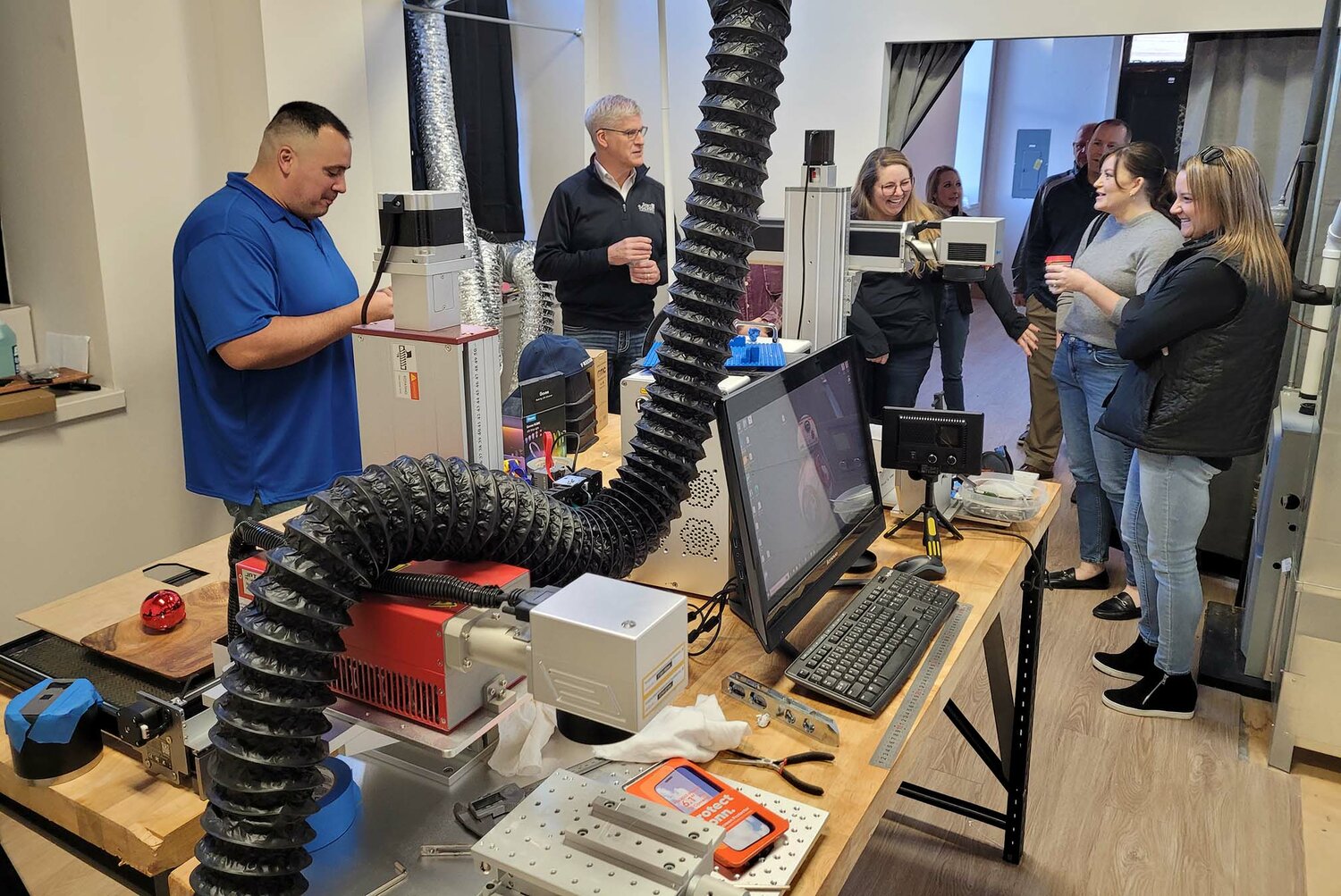 Anthony Montez, far left, demonstrates some of his laser etching work to Fort Madison Chamber of Commerce Ambassadors Friday morning at his new retail outlet at 618 8th Street in Fort Madison.