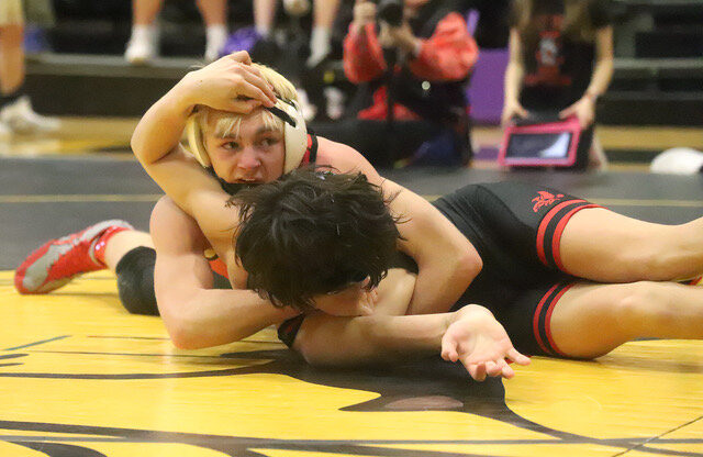 Fort Madison's Luke Vanderpool looks to his corner for advice as he struggles to get Iowa City High's Chris Davis' shoulders on the mat Saturday at Bettendorf High School in the Class 3A District qualifier. Vanderpool would falter in the third period eliminating him from a state tournament spot.