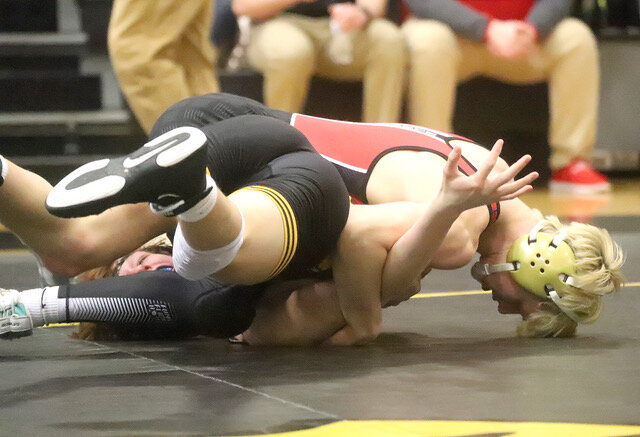 Senior Bloodhound Nolan Riddle works a pin at 157 lbs. in his second match of the day at the Bettendorf 3A district qualifier Saturday. Riddle would finish runner-up and qualify for the state tournament next week.