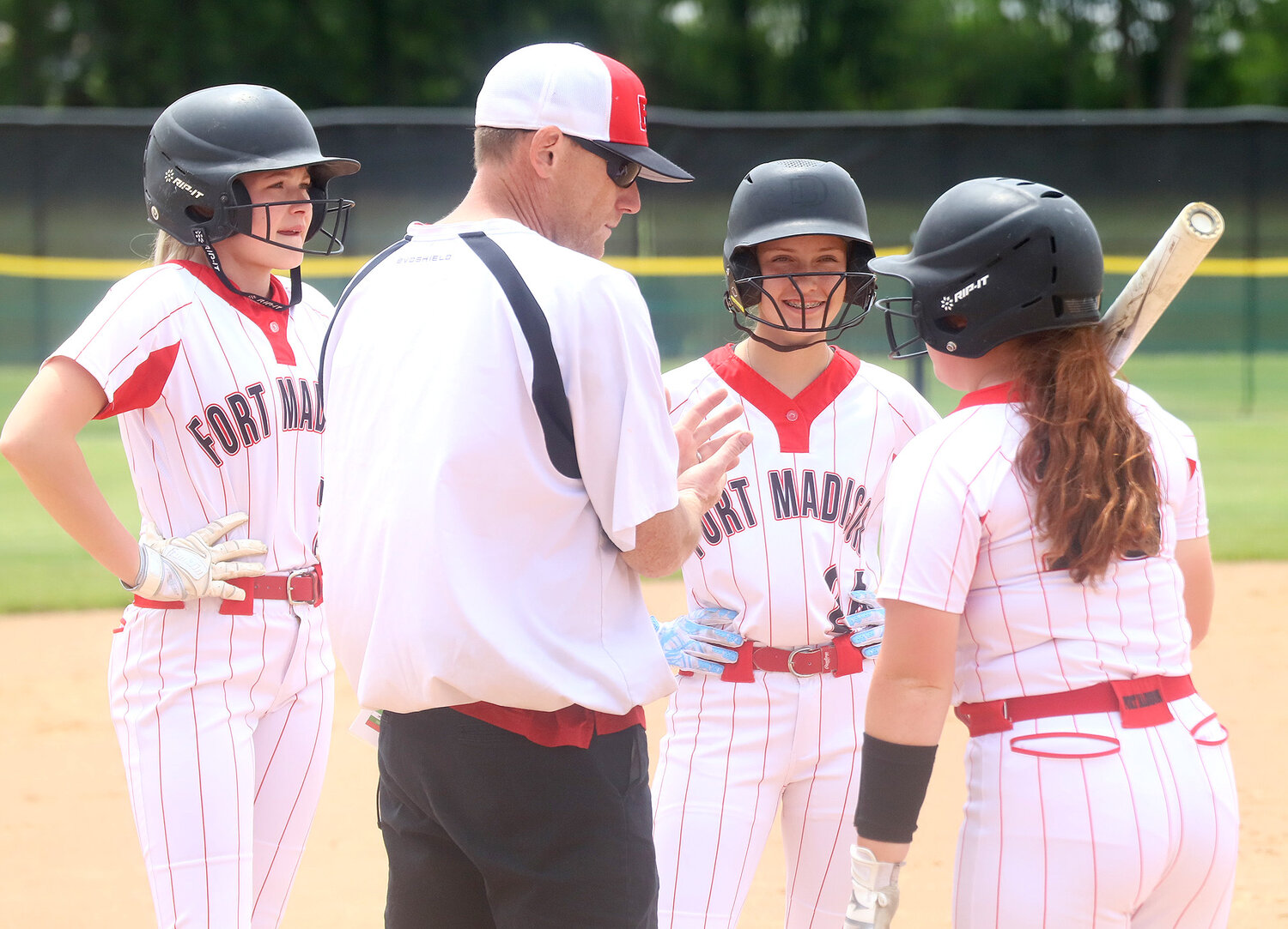 Fort Madison Head softball coach Jared Rehm talks with from left to right Taylor Johnson, Reilynn Turnbull, and Kylie Lumino during a Fairfield timeout Tuesday afternoon at Baxter Sports Complex in Fort Madison.