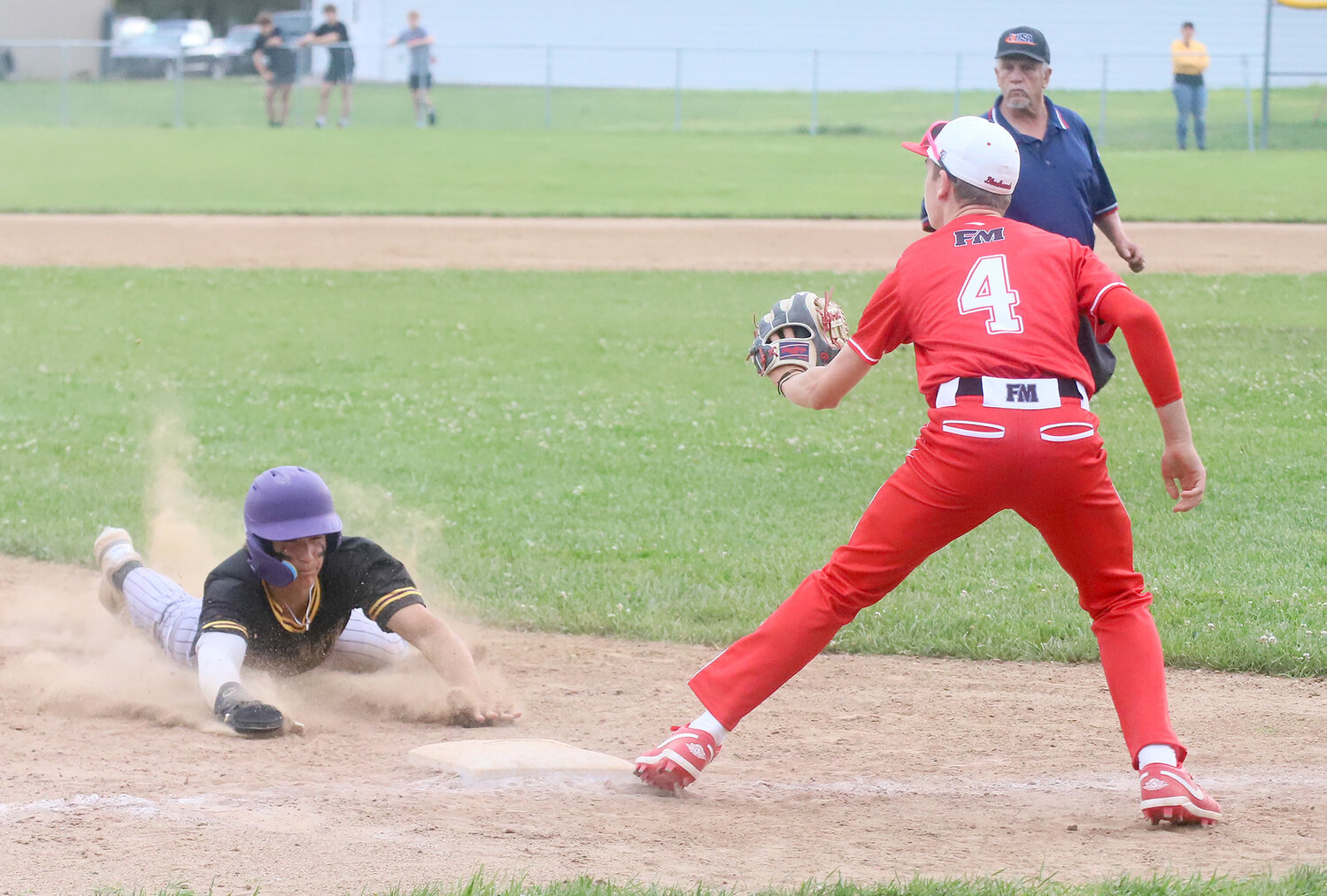 The Hounds' Stefan Berlett (4) waits on a throw at third as a Muskie slides in head first. Fort Madison fell to .500 on the season with two losses Friday night to Muscatine.