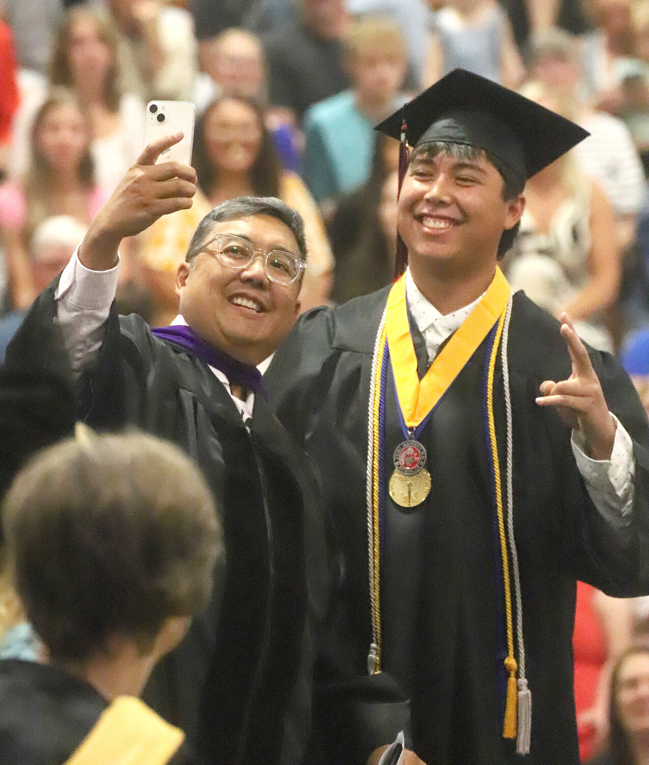 FMHS Senior Class President Oliver Santiago, right, gets a selfie with board member and father Mio Santiago as he receives his diploma Saturday morning at Fort Madison High School.