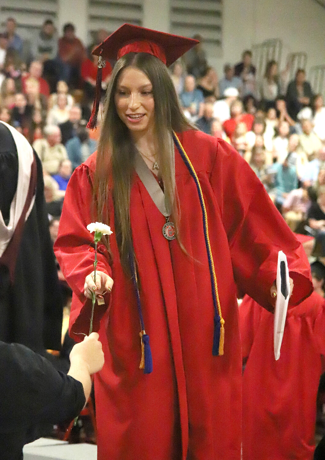 Senior Amy Yasenchok receives a carnation, and a diploma, Saturday during commencement exercises at Fort Madison High School.