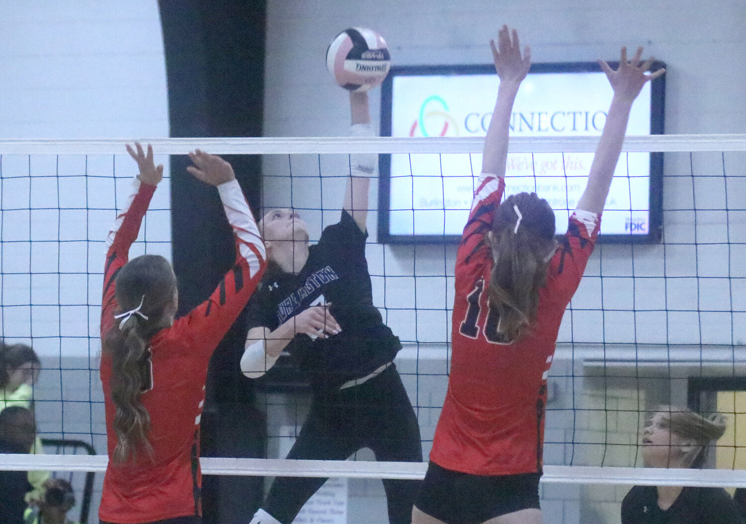 Fort Madison's Alaina Schwerin (9) and Sydney McEntee (10) try to block an attack from Burlington's Sophia Young (27) in the second set of Tuesday's 3-set win for the Grayhounds in Fort Madison.