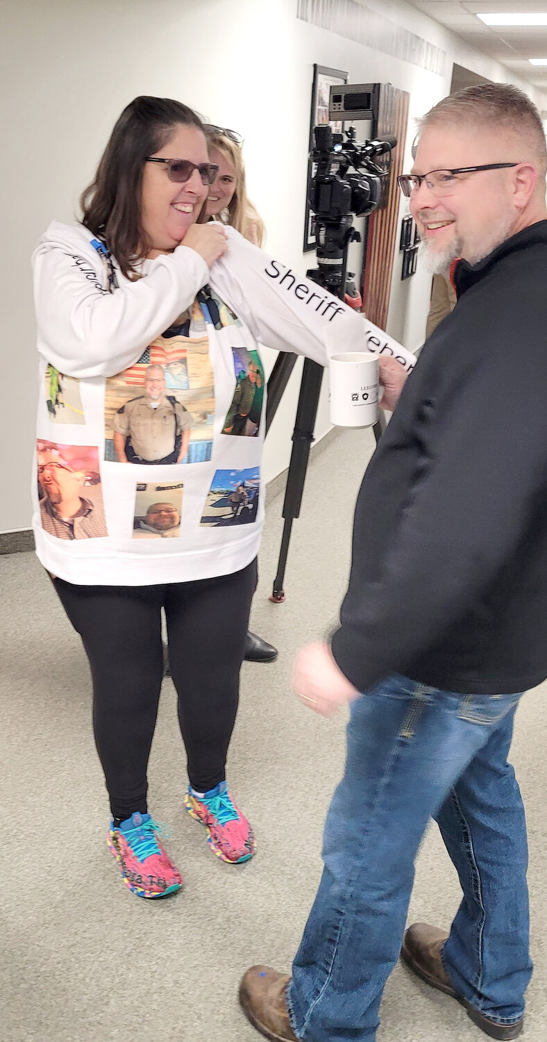 Lee County Sheriff Stacy Weber talks with a family member who had a sweatshirt made special for his retirement reception Thursday afternoon at the Lee County Sheriff's Office.