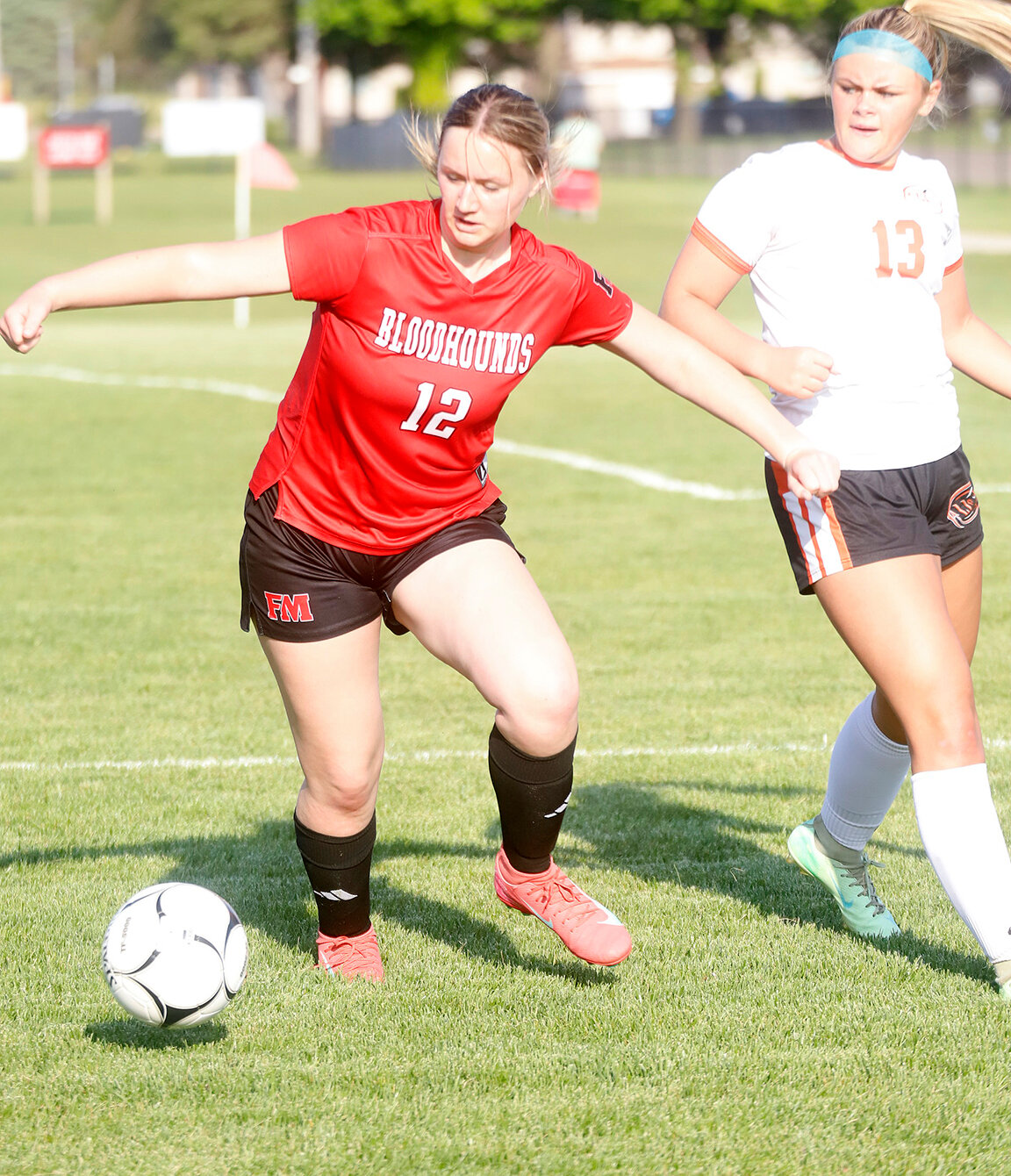 Adalyn Kruse (12) tries to get the ball out of Washington territory in the 2nd half Thursday night at Baxter Sports Complex. The Lady Hounds defense held the Demons to just one goal in a 9-1 Fort Madison win.