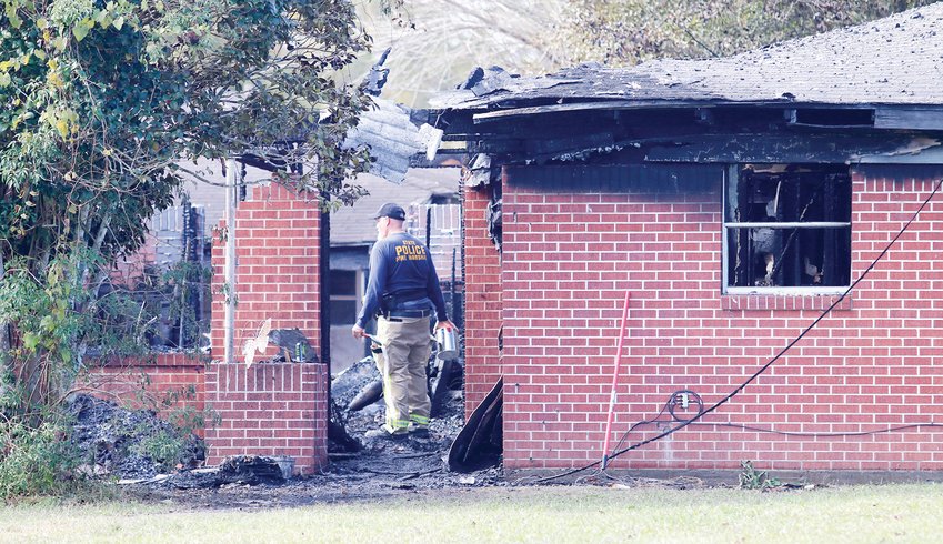 An investigator combs through the burnt remains of a home blaze in which a couple died on Nov. 30. The home was located at the corner of Old Spurger Road and Cardinal Lane, north of Silsbee.