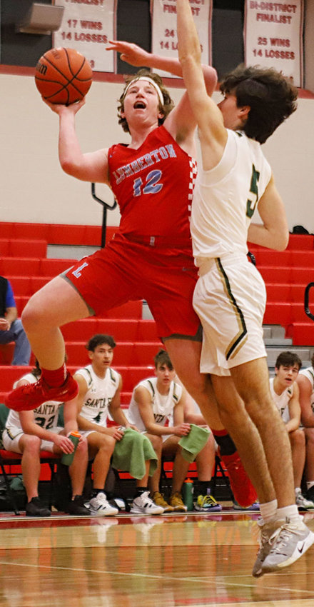 Lumberton&rsquo;s Timothy Holt (12) goes up for a layup against a Sante Fe defender on Dec. 11. For his play, Holt was selected to the all-tournament team.