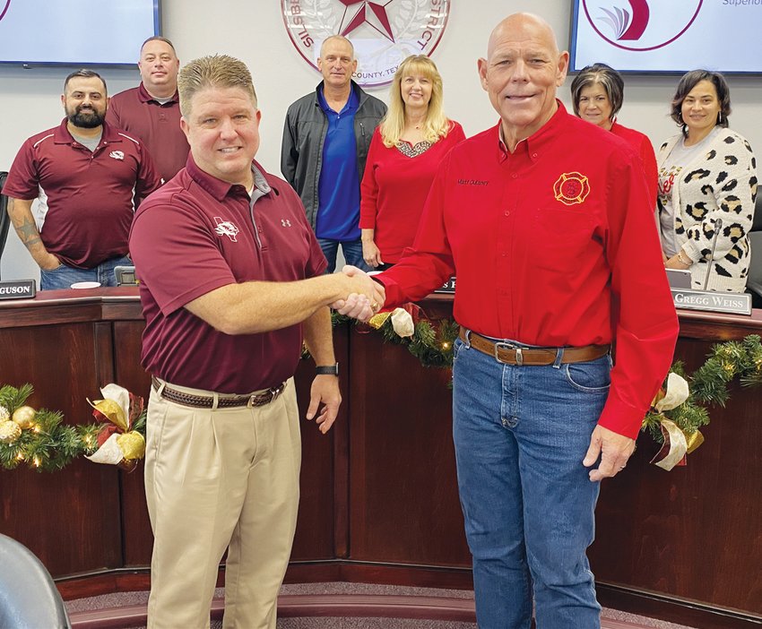 SISD Superintendent Dr. Gregg Weiss (left) and Matt Dulaney, president of Hardin County ESD No. 6, shake hands after the school board approved the sale of the former John Henry Kirby Elementary School property to ESD No. 6.