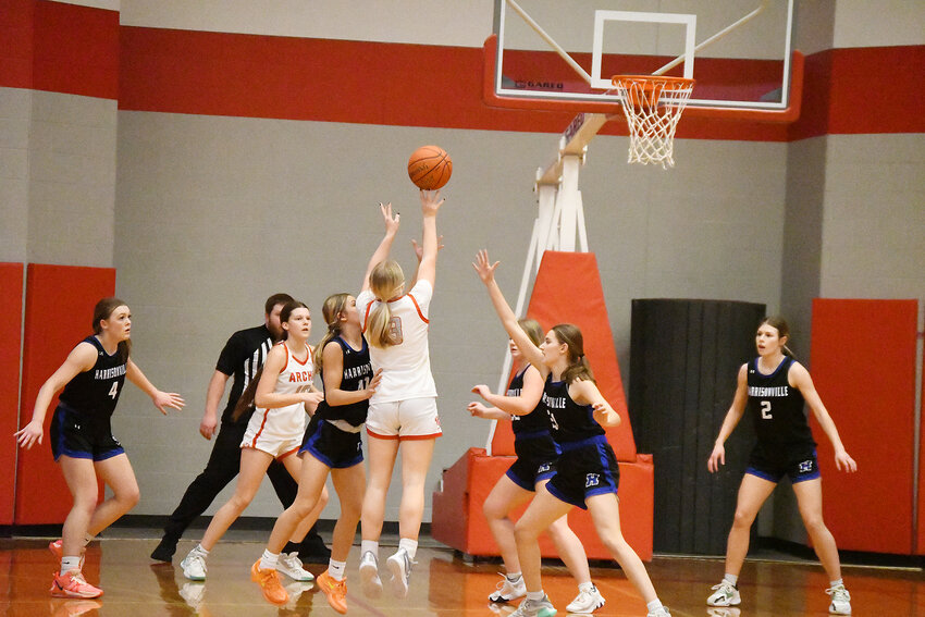 Archie senior Kaitlyn Newport attempts a mid-range jumper between Harrisonville defenders Friday night. Newport scored 17 points in the Lady Whirlwinds 65-30 victory.