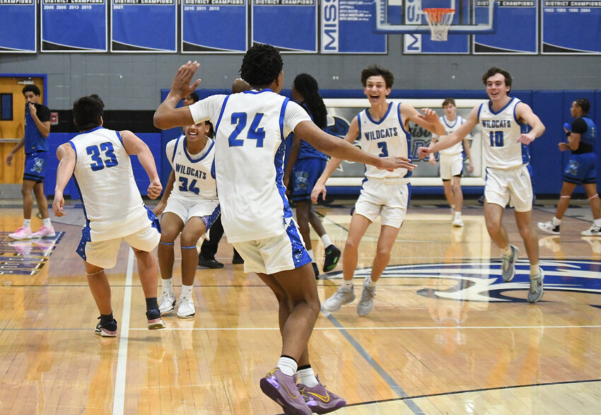 Harrisonville senior Michael Moore (24) runs on the court to celebrate with teammates after the Wildcats beat Center, 54-45, clinching at least a share of the Missouri River Valley Conference West title Friday night.