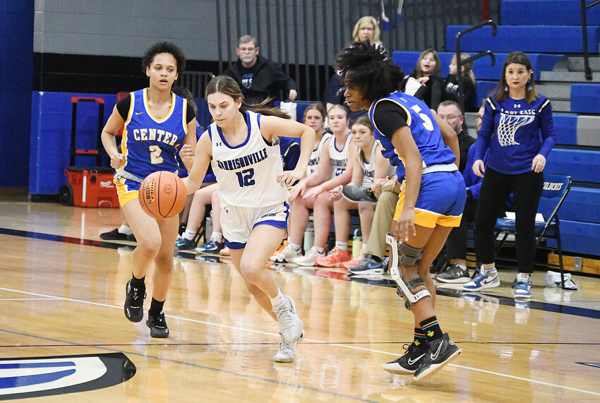 Harrisonville freshman Presley Feeback (12) dribbles between two Center players after stealing the ball during the first half of Monday’s 68-17 win in the first round of the Class 4 District 13 contest. Feeback scored eight points in a game where all 11 Lady Wildcats scored.