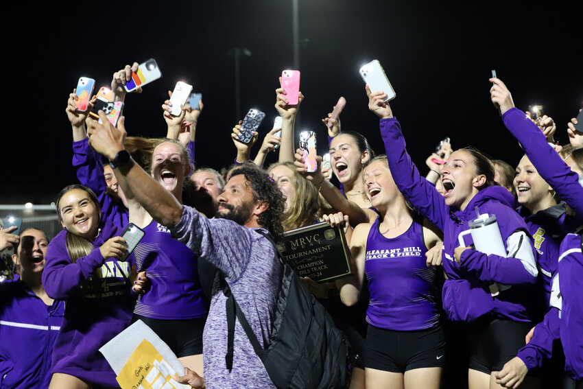 Pleasant Hill girls track and field coach Patrick Dent, front and center, celebrates winning the Missouri River Valley Conference West championship Monday night in Warrensburg. The Chicks have won the conference title in back-to-back years. The team celebrated by making a video after the meet.