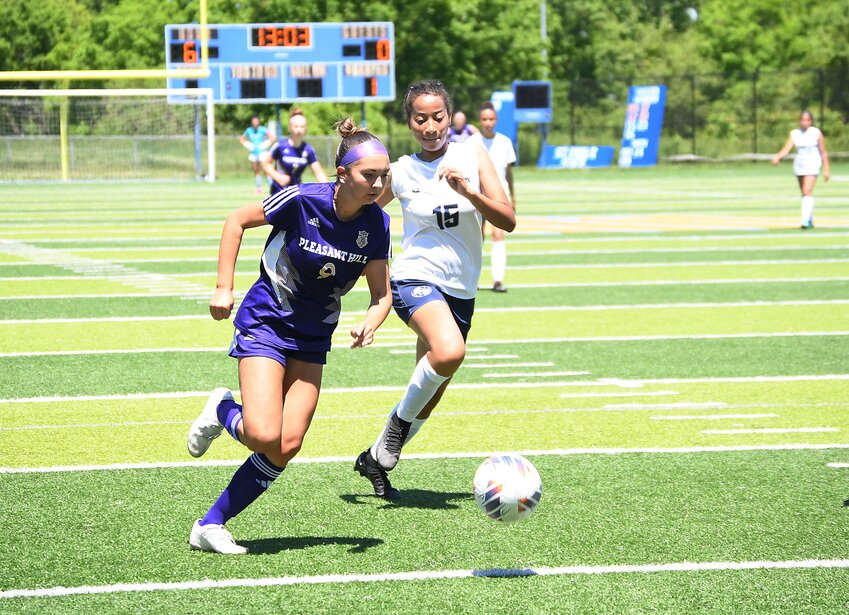 Pleasant Hill freshman Anesa Scrogham, left, dribbles around a defender Saturday during the Class 2 District 7 game. Pleasant Hill beat Ewing Marion Kauffman 12-0 in the quarterfinal contest.