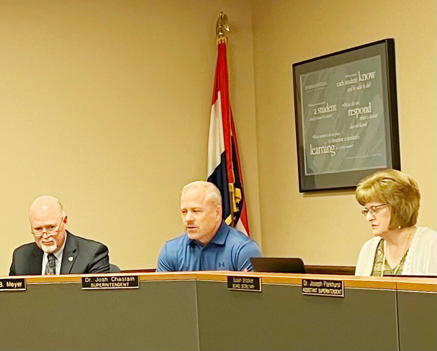 Harrisonville Schools Superintendent Josh Chastain, center, leads discussion at a recent school board meeting.